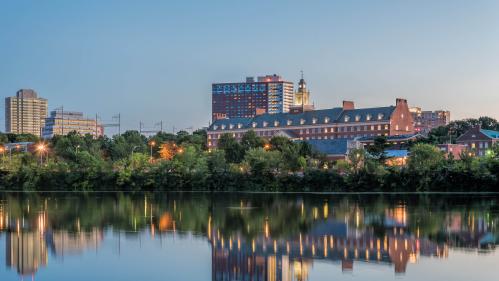 Exteriors of the Honors College of Rutgers in New Brunswick across the Raritan River with reflection in water