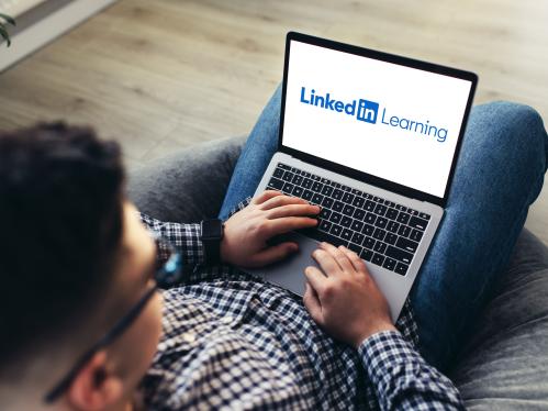 man-using-laptop-wearing-glasses-cushioned-furniture-blurred-background-high-quality-photo-linkedin-learning