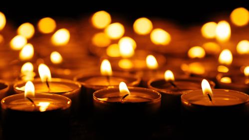 Picture of a group of lit candles against a dark background