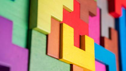 Colorful building blocks of different shapes and sizes fitting together
