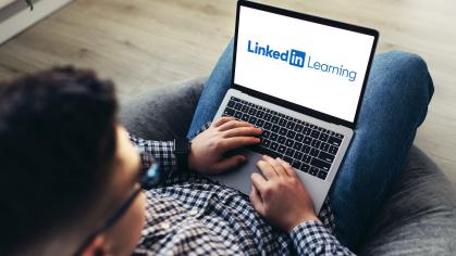 man-using-laptop-wearing-glasses-cushioned-furniture-blurred-background-high-quality-photo-linkedin-learning