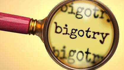 A magnifying glass held up over the word Bigotry