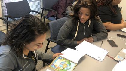 Promise Parent Leadership Academy participants practice a shared reading activity during literacy support training and professional development. 