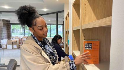 Jassadi Moore (left), a Rutgers graduate student, and undergraduate Stephanie Lopez-Perez (right) add books from Cheryl A. Wall’s collection to the shelves of the new reading room at the Paul Robeson Cultural Center dedicated to the late Rutgers professor.