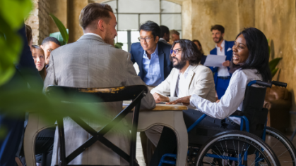 Woman in wheelchair conversing with colleagues