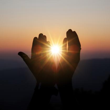 spiritual prayer hands sun shine with blurred beautiful sunset