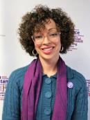 Rebecca Vazquez - A spanish woman with short curly hair. She is wearing a licite glasses, a teal sweater and a purple scarf