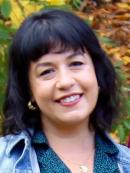 Kaylin Padovono - she has black hair cut in a bob with bangs. she is wearing a blue polkadot collared shirt with a light blue jacket