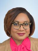 Francine Henry is wearing brown and black framed glasses with a pink blouse and tan jacket