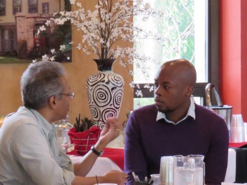 A professor speaking to an african american man at an RCN orientation