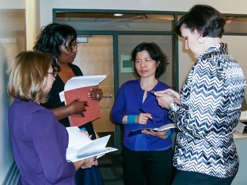 A group of women having a discussion with a senior faculty member