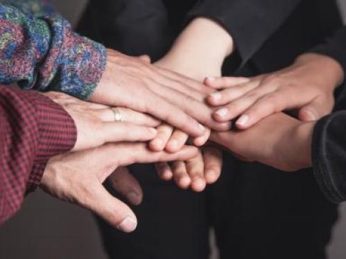 photo of a hands from diverse backgrounds on top of each other
