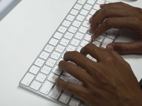 African american hands typing on a white keyboard