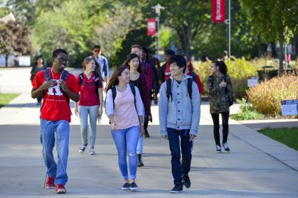 Young african american male student, young caucasion female student, young male asian student smiling walking on Livingston campus